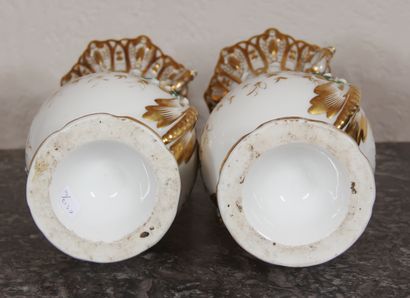 null A pair of white and gilt porcelain openwork vases on a pedestal, with two handles...