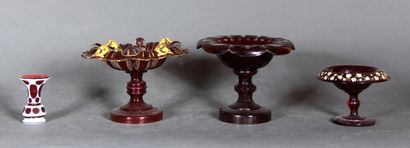 null Set of three red transparent glass display stands, some with gold foliage decoration...