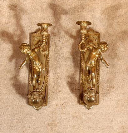 null A pair of bronze sconces decorated with putti holding a light arm

H : 29 c...
