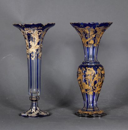 null Two transparent and blue overlay glass vases with white and gilded scroll decoration.

H...
