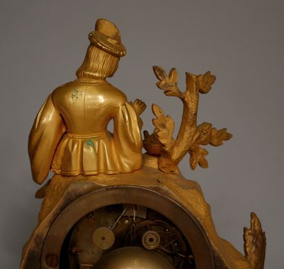 null A romantic ormolu and brass quadripod clock, the movement surmounted by a courtier...