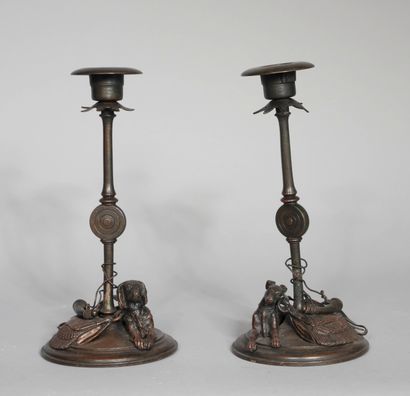null Pair of candlesticks in patinated metal decorated on the base with a sitting...
