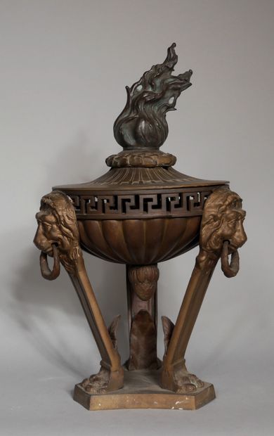 null A tripod patinated bronze incense burner with lion's head handles and a flame-shaped...