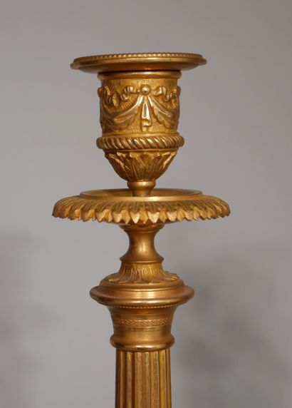 null A pair of bronze candlesticks with a fluted column in the Louis XVI style

H:...