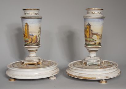 null A pair of white and gilt porcelain vases on a pedestal decorated with a polychrome...