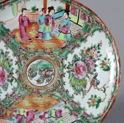 null A round polychrome porcelain plate decorated with flowers and characters, Canton

D...