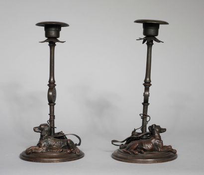 null Pair of candlesticks in patinated metal decorated on the base with a sitting...