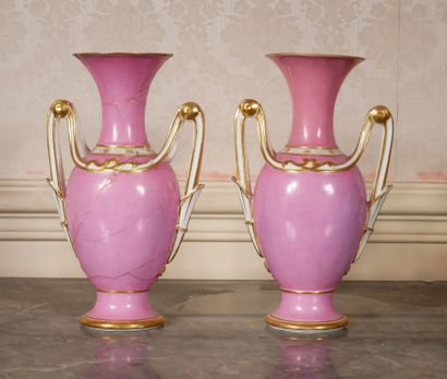 null A pair of two-handled vases in pink porcelain, gilded and decorated with medallions...