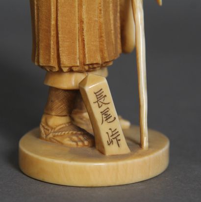 null Okimono en ivoire et rehauts bruns, représentant un moine levant une lanterne...