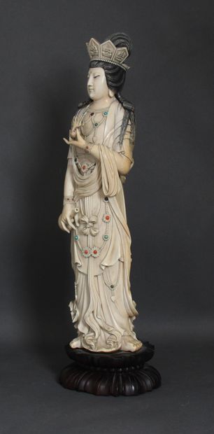 null Grand sujet en ivoire rehaussé de brun représentant la déesse Guanyin debout,...