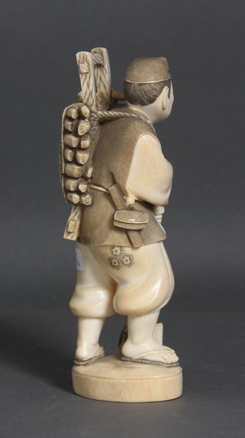 null Okimono en ivoire et rehauts bruns, représentant un bûcheron, tenant une hache,...