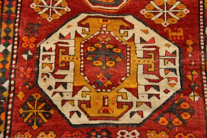 null Polychrome wool carpet decorated with three medallions with stylized decoration...