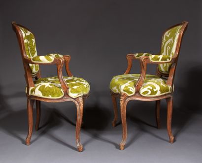 null A pair of Louis XV style cabriolets armchairs in natural wood carved with flowers.

Seat...