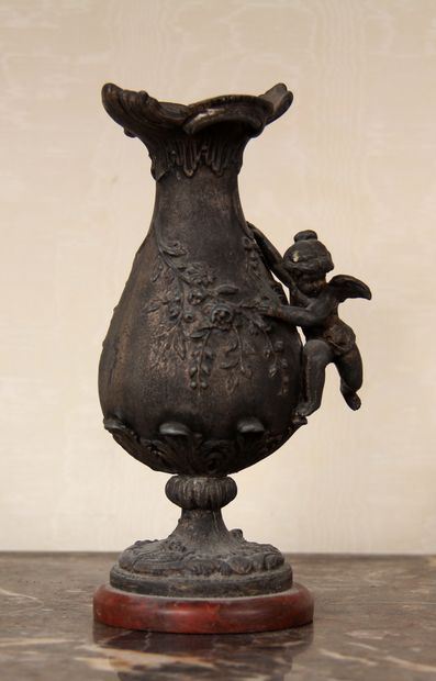 null Vase sur piédouche en métal à décor en relief d'un ange et feuillage, contre...