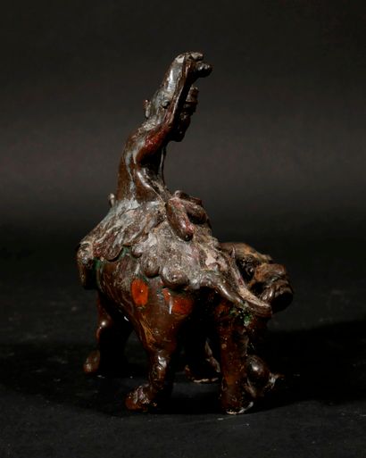 null *Sculpture en métal patiné en forme d'un personnage sur un chien de Fô, Chine

H...