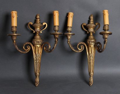 null A pair of bronze two-light sconces decorated with a fire pot, Louis XVI style

H...