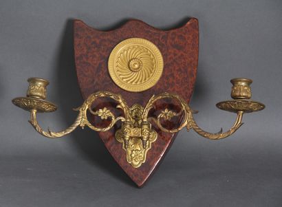 null A pair of sconces in the shape of a shield in burl veneer decorated with a round...