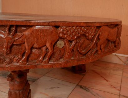 null *Table basse en bois naturel sculptée d'une frise d'éléphants et de chasse,...
