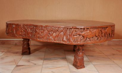 null *Table basse en bois naturel sculptée d'une frise d'éléphants et de chasse,...