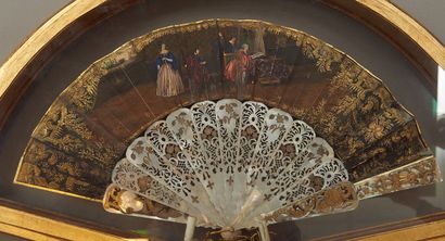 null A mother-of-pearl fan with openwork and gilt decoration, the leaf painted with...