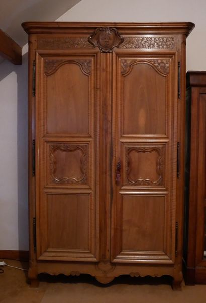 null A large natural wood wedding cabinet with two three-panel doors, the pediment...