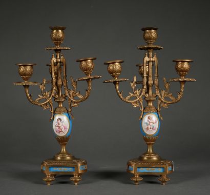 null *Paire de candélabres quadripodes en bronze et porcelaine à décor de putti et...