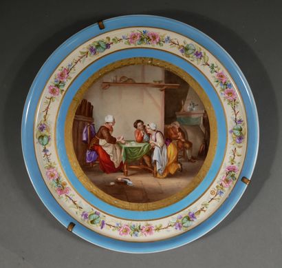 null *Important plat rond en porcelaine polychrome et doré orné au centre d'une scène...