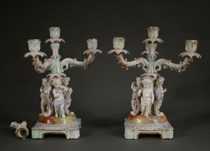 null Pair of polychrome porcelain candelabras decorated with putti on a quadripod...