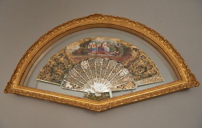 null A mother-of-pearl fan with openwork and gilt decoration, the leaf painted with...