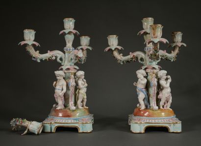 null Pair of polychrome porcelain candelabras decorated with putti on a quadripod...