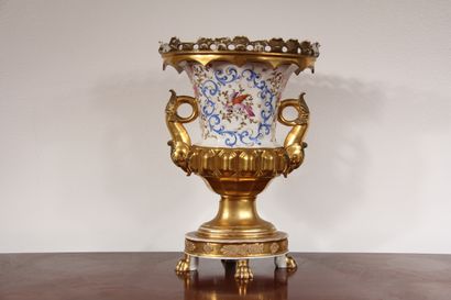 null A polychrome and gilt porcelain vase on a pedestal with two handles, decorated...