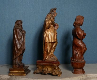 null Trois statuettes en bois naturel et redoré représentant des Saints et enfant...