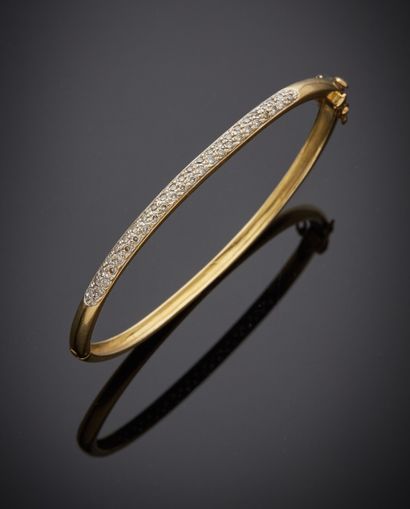 null Bracelet rigide ouvrant en or jaune 750 millièmes, le centre orné d'un pavage...