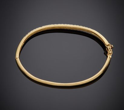 null Bracelet rigide ouvrant en or jaune 750 millièmes, le centre orné d'un pavage...