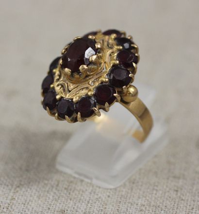 null *Flower ring in 18k yellow gold set with a garnet in the center and a rim of...
