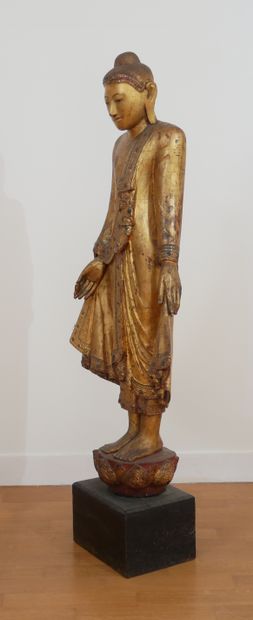 null Statuette en bois laqué et doré représentant Bouddha debout le bras gauche tenant...