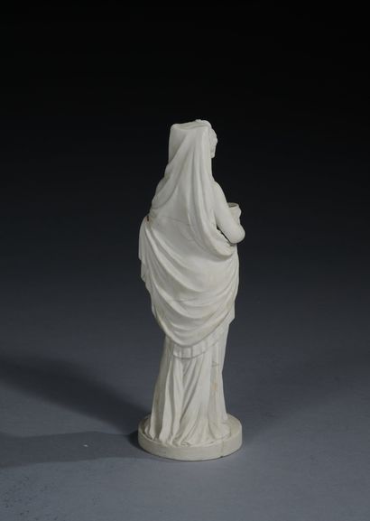 null Bisque porcelain statuette representing a vestal, draped, and holding a cup...
