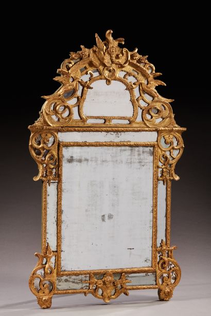 null Large gilded and carved wood mirror, the pediment topped by a large rocaille...