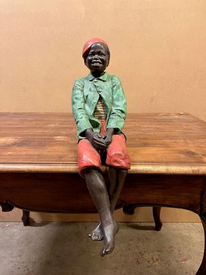 null Sculpture en plâtre polychrome représentant un jeune garçon noir assis à la...