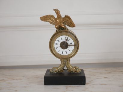 null Pendule en bronze surmontée d'un aigle reposant sur un socle en marbre noir...