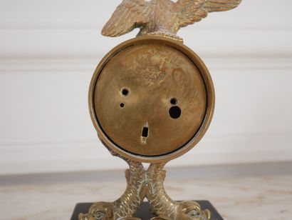 null Pendule en bronze surmontée d'un aigle reposant sur un socle en marbre noir...