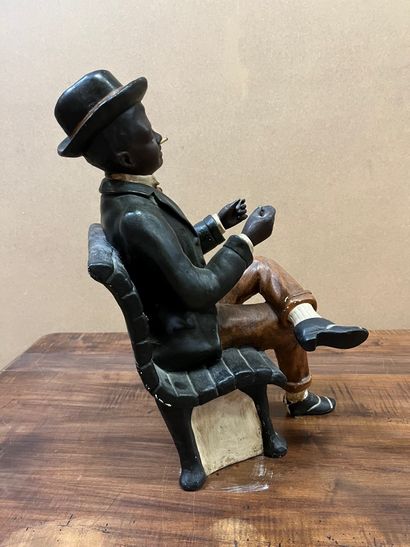 null Sculpture en plâtre polychrome représentant un jeune noir assis, à la cigarette...