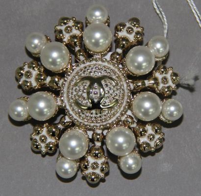 CHANEL Broche flocon de neige stylisée en métal doré émaillé blanc, orné de perles...