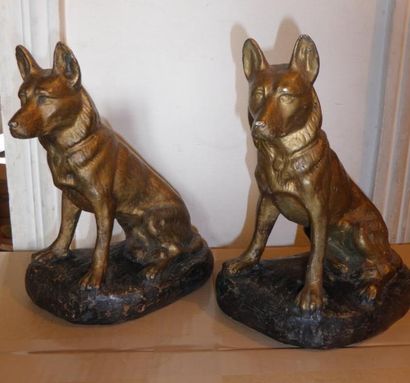 null Deux sculptures en plâtre patinés et dorés représentant un chien de chasse assis....