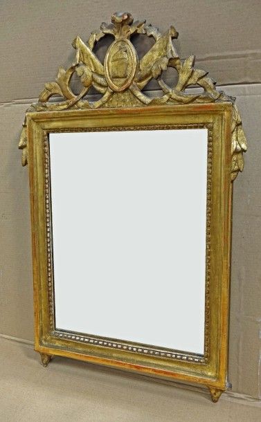 null Miroir en bois sculpté et doré, le fronton ajouré à décor d'un bonnet phrygien...