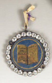 null "Bijou maçonnique à décor de livre ouvert avec l'inscription : "Règlements et...