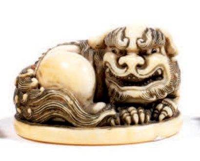 null Netsuke en ivoire incrusté de petites pierres dures, représentant un shishi...
