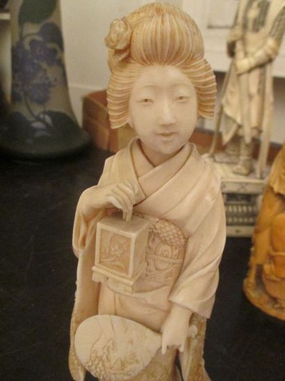 null Okimono en ivoire représentant une geisha tenant une lanterne et un uchiwa,...