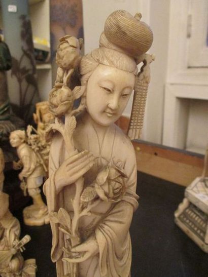 null Sujet en ivoire représentant une déesse debout tenant une branche de roses.
Chine,...