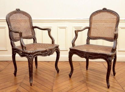 null Paire de fauteuils cannés à dossier plat en bois relaqué marron, à décor sculpté...